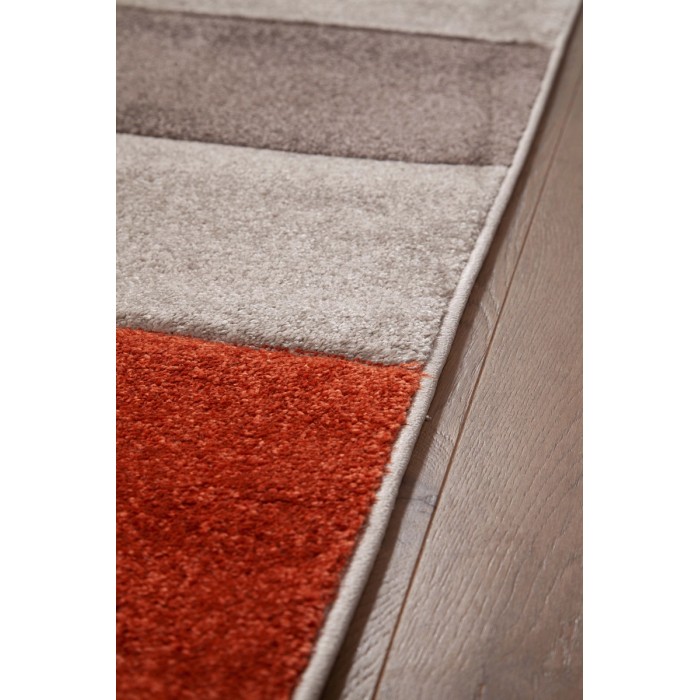Dettaglio di un tappeto moderno a strisce in arancione, grigio e beige.