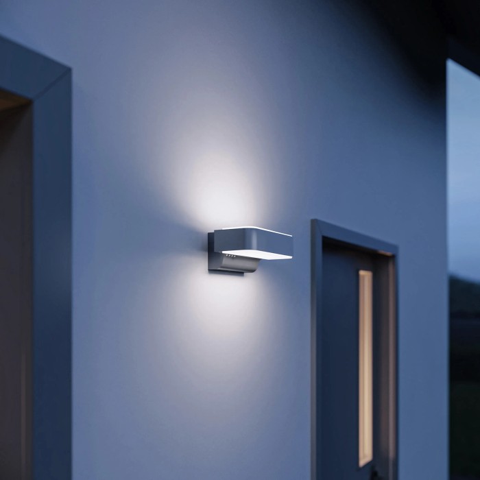 Moderna lampada da esterno a LED Steinel L 810 SC in antracite con effetto up and downlight su parete di casa.