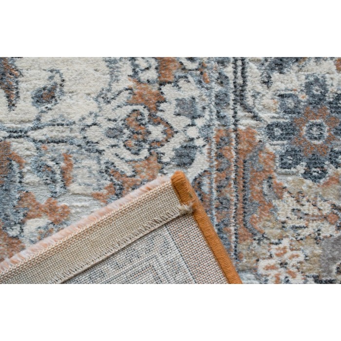 Dettaglio del tappeto moderno t.b.t. con motivo floreale in beige, grigio e arancione.