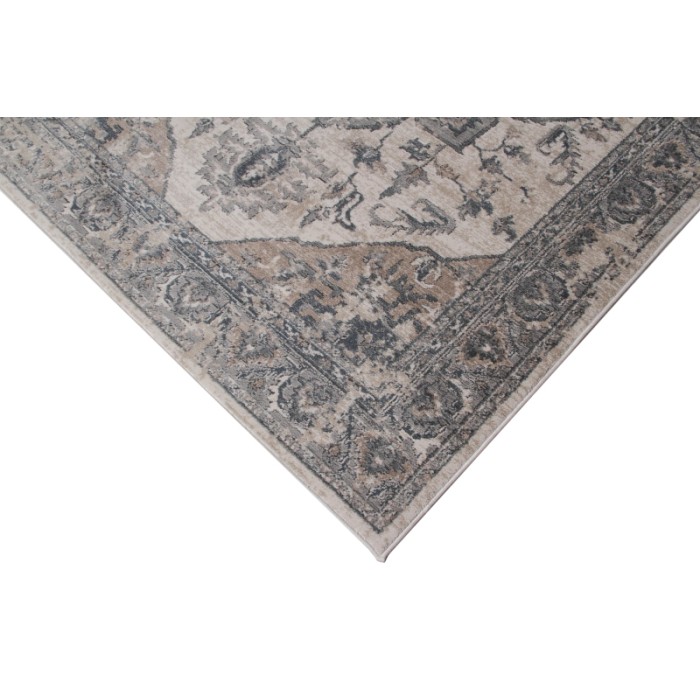Dettaglio di un tappeto vintage beige con motivo floreale.