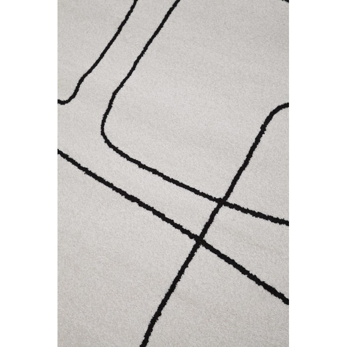Tappeto moderno con motivo astratto a linee nere su sfondo chiaro.