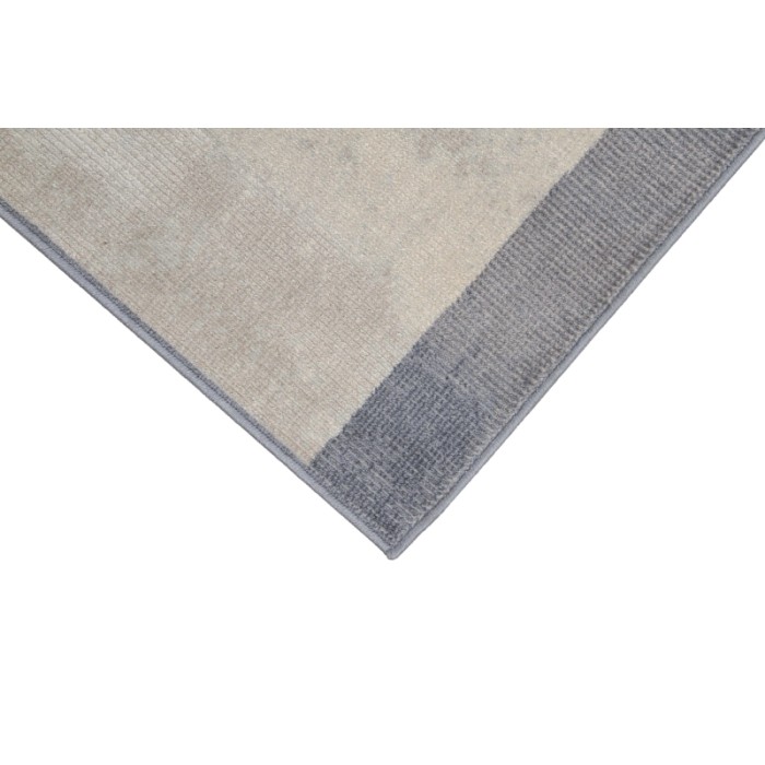 Dettaglio di un tappeto moderno in beige e grigio.