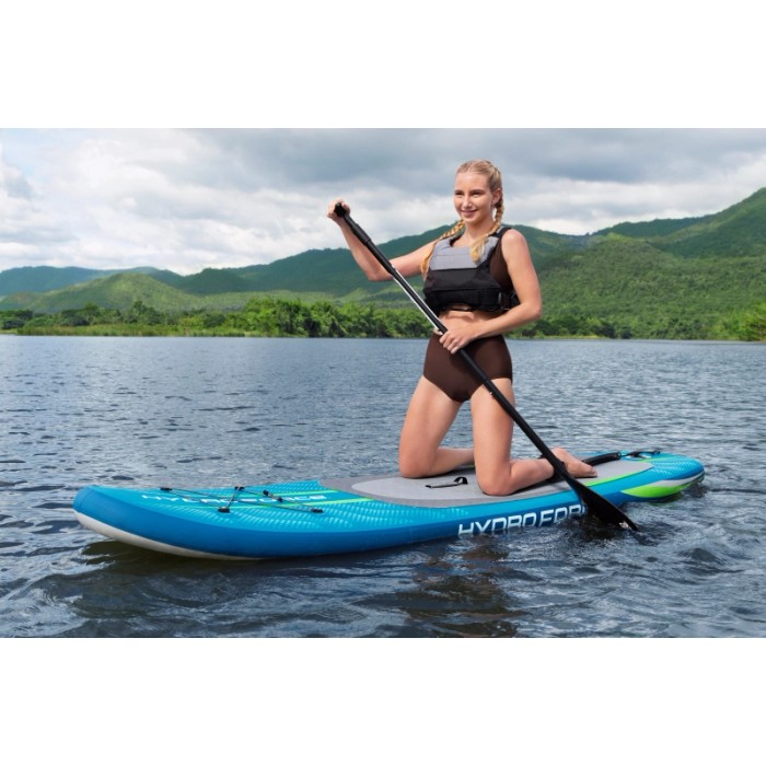 Donna su tavola SUP Bestway Aqua Journey blu con pagaia sull'acqua.