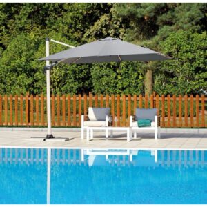Ombrellone a braccio t.b.t. grigio accanto a piscina e mobili da giardino.