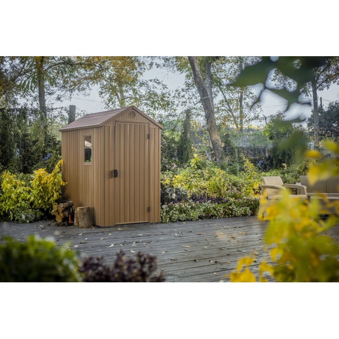 Casetta da giardino in plastica marrone con finestra e porta in un ambiente da giardino.