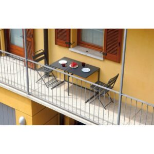 Set di mobili da balcone grigio con tavolo e due sedie su un balcone.