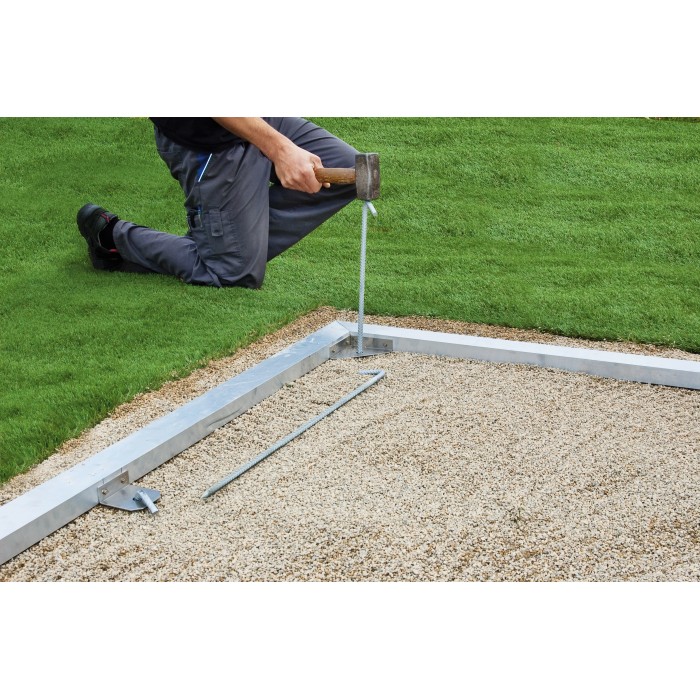 Telaio base Biohort per casetta da giardino CasaNova: installazione su letto di ghiaia con martello e picchetto.