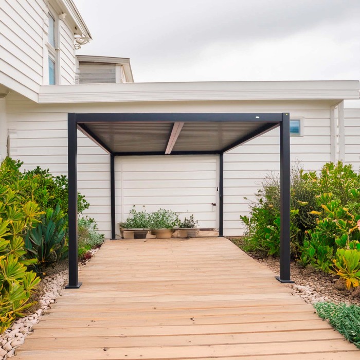 Gazebo t.b.t. moderno grigio con struttura nera su patio in legno in giardino.