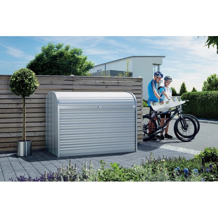 Box da giardino Biohort StoreMax 160 in argento metallizzato con serranda e due biciclette accanto.