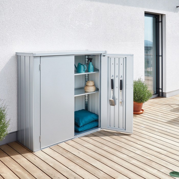Armadio da terrazza Biohort Romeo Gr. M argentato con anta aperta su una terrazza. Armadio da giardino con ripiani.
