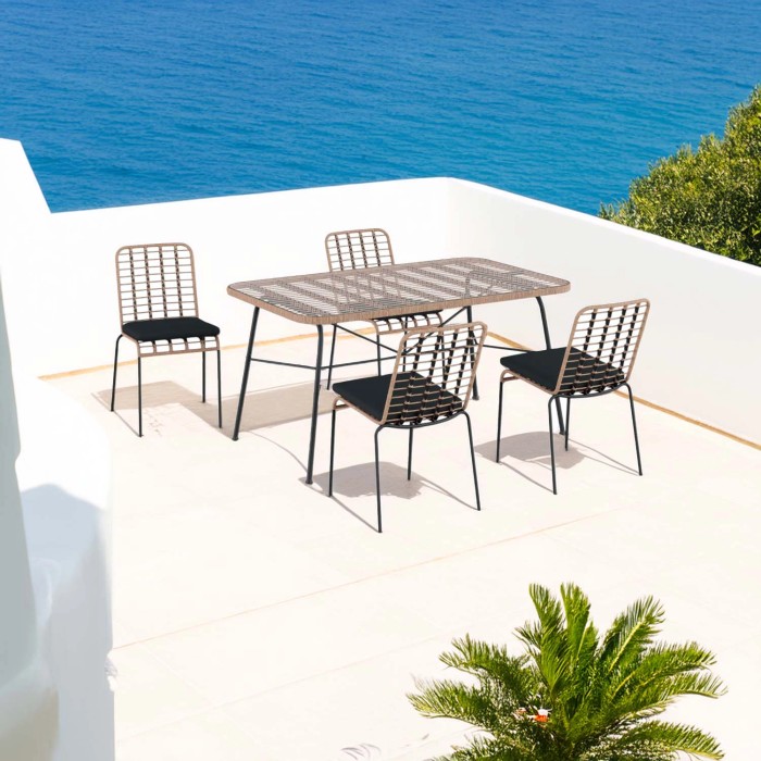 Set di mobili da giardino t.b.t. con tavolo e quattro sedie su una terrazza con vista mare.