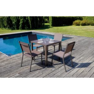 Tavolo da giardino quadrato con quattro sedie su un ponte di legno a bordo piscina.