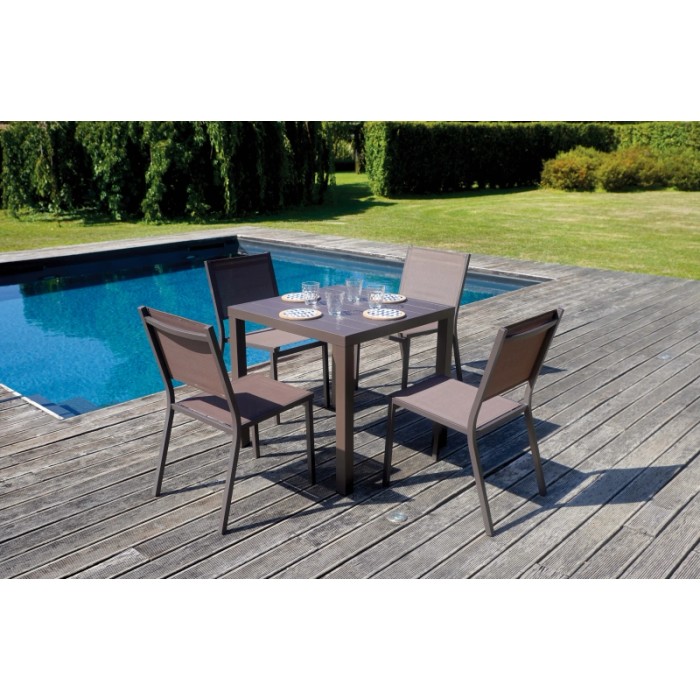 Tavolo da giardino quadrato con quattro sedie su un ponte di legno a bordo piscina.