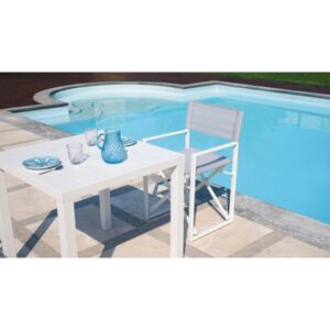 Tavolo da giardino bianco con sedia a bordo piscina. Ideale per il relax all'aperto.