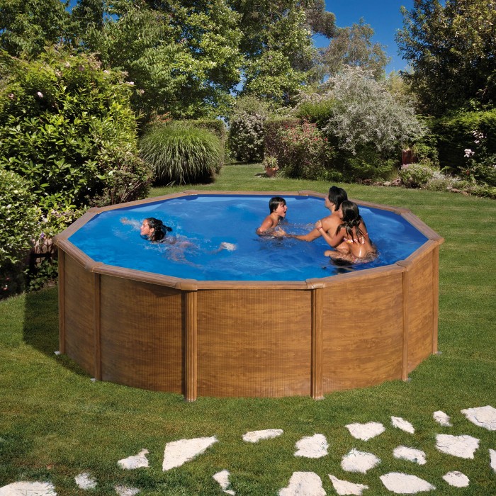 Piscina rotonda Gre Pool Pacific effetto legno, Ø 300 cm, con famiglia in giardino.
