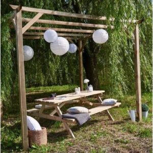 Tettoia per auto in legno con tavolo da picnic e lanterne di carta in giardino.