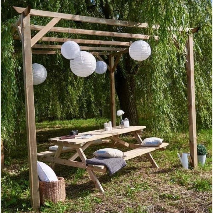 Tettoia per auto in legno con tavolo da picnic e lanterne di carta in giardino.