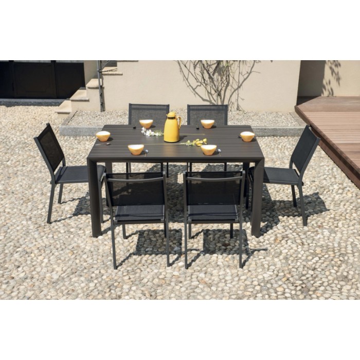 Set tavolo da giardino con 6 sedie su ghiaia. Tavolo e sedie in grigio scuro.