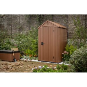 Casetta da giardino in plastica marrone in un ambiente da giardino. Ideale per riporre gli attrezzi da giardinaggio.