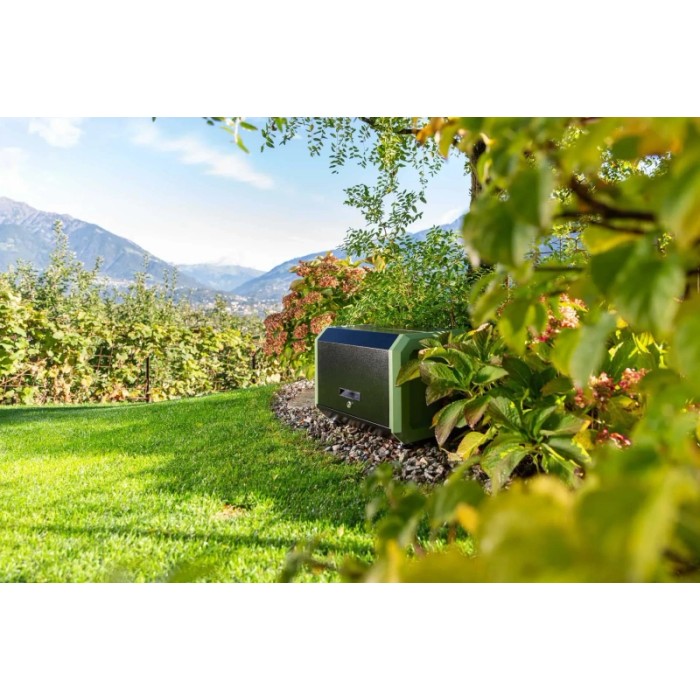 Pompa a pressione t.b.t. in giardino con ambiente verde e montagne sullo sfondo.