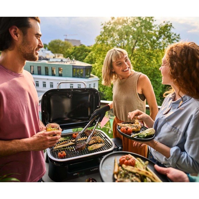 Scena con barbecue elettrico t.b.t. utilizzato con amici sul balcone.