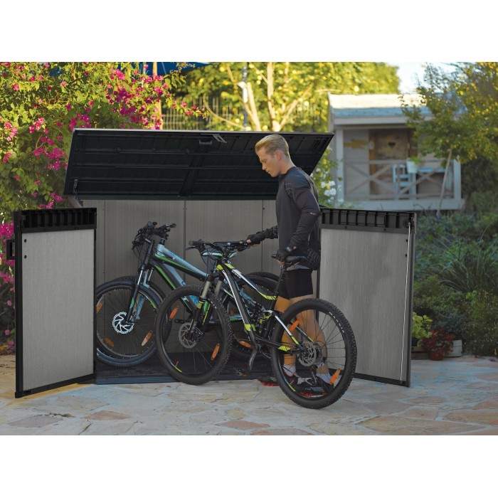 Box universale Keter Grande-Store 2.100 l con biciclette e uomo che apre.