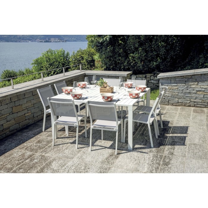 Tavolo da giardino bianco con sedie, apparecchiato con ciotole. Ideale per mangiare all'aperto.
