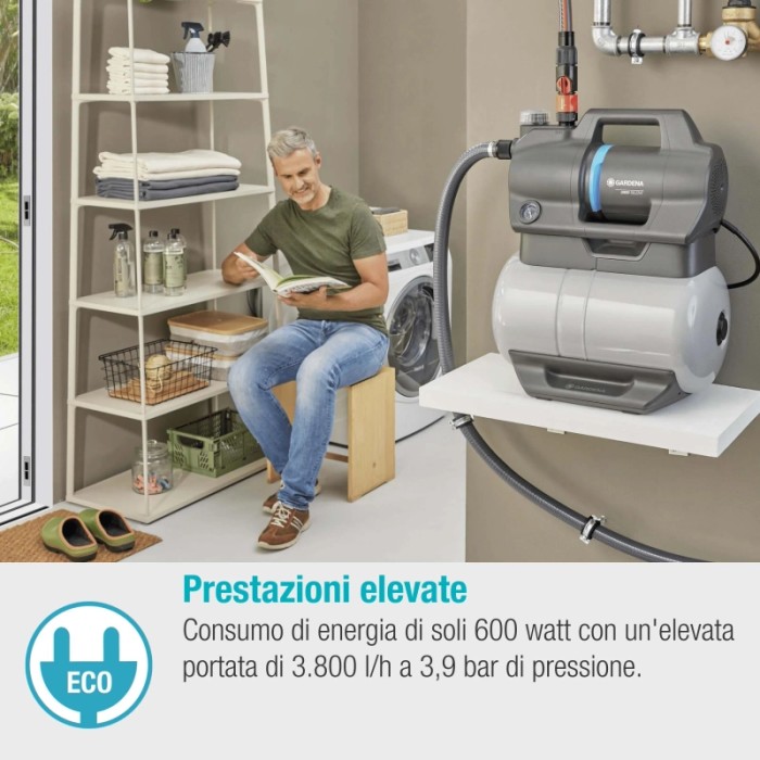 Pompa da giardino grigia in interni con uomo che legge. Pompa elettrica per irrigazione giardino.