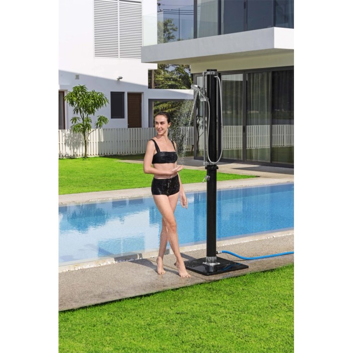 Donna sotto la doccia da giardino t.b.t. a bordo piscina. Doccia nera con soffione.