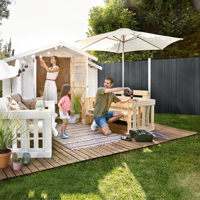 Famiglia in giardino con recinzione privacy in WPC antracite e casetta da giardino.