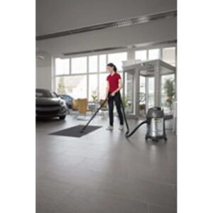 Donna aspira un tappeto in uno showroom con un aspirapolvere t.b.t.